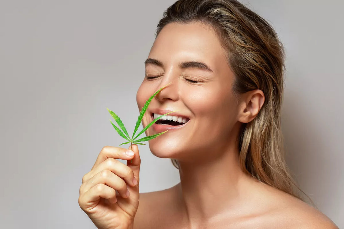 CBD skincare. Woman with a cannabis leaf on gray background